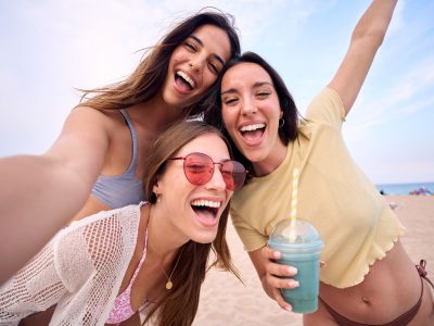 Young women taking a group picture on the beach